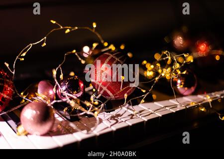 Festive decor on piano keys indoors, closeup. Christmas music Stock Photo