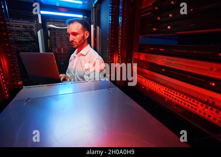Data center administrator inspecting server rack software Stock Photo