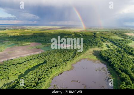 Aerial image of beautiful wild landscape shoot from drone with two rainbows on dramatic sky Stock Photo