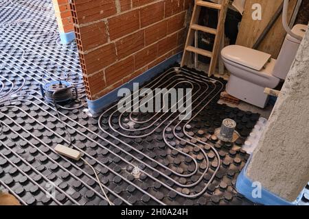 Radiant underfloor heating installation in a bathroom. Stock Photo