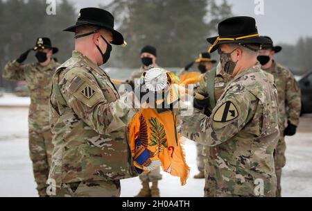 2nd Battalion, 8th Cavalry Regiment, 1st Armored Brigade Combat Team, 1st Cavalry Division Commander Lt. Col. Steven E. Jackowski and Command Sgt. Maj. Jesus Pena carefully unfurl the battalion’s colors Jan. 4, 2021. The small, socially distanced ceremony officially signified the arrival of the battalion to the Pabrade Training Area, Lithuania. Stock Photo