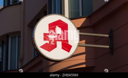 Munich, Germany - Mar 30, 2021: Apotheke (pharmacy) sign at the facade of a building. Traditional logo.