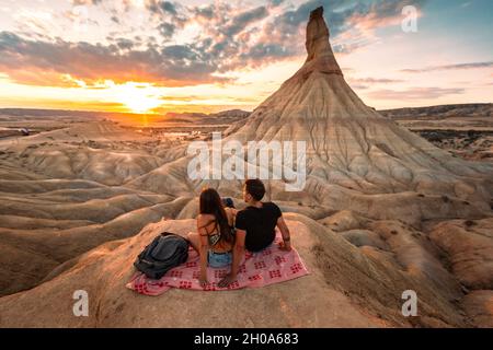 One young man and one young woman watching the sunset at Castildetierra in Bardenas Reales desert, Navarra, Basque Country. Stock Photo