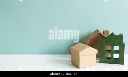 House model on white ceramic mosaic tile table. mint background. Real estate concept Stock Photo