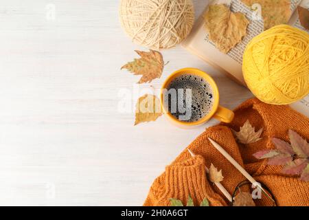 Concept of autumn with yarn balls on white wooden background. Stock Photo
