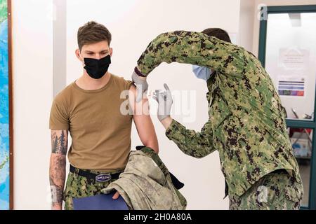 SILVERDALE, Wash. (Jan. 6, 2021) Sonar Technician (Submarines) 2nd Class Darren Rosser, from Crossville, Tennessee, a Sailor assigned to the Blue crew of the Ohio-class ballistic-missile submarine USS Henry M. Jackson (SSBN 730), receives his first dose of the COVID-19 vaccine from Naval Hospital Bremerton Hospitalman Curtis Boney, from San Diego, Jan. 6. Hospital Corpsmen from around the Puget Sound volunteered to participate in the COVID-19 vaccination effort for strategic deterrent forces at the Branch Health Education Center on board Naval Base Kitsap-Bangor. Stock Photo