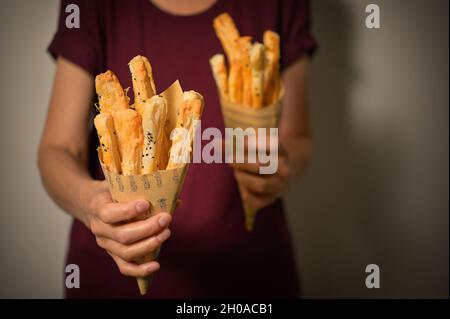 Salted Cheese Straws and Sesame Seeds In A Paper Cone Stock Photo