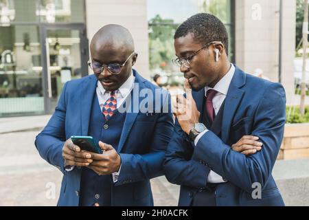 Meeting of two partners black african american businessman in suits and glasses outdoors Stock Photo