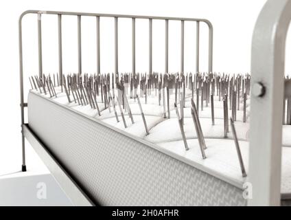 A literal metaphor showing a metal framed bed with a mattress covered in nails on an isolated white studio background - 3D render Stock Photo