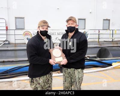 210113-N-AY795-019 GROTON, Conn. (January 12, 2021) – Capt. Matthew Boland, commodore of Submarine Squadron (SUBRON) TWELVE, right, presents the Battle “E” award to the crew of the USS Newport News (SSN 750), represented by Cmdr. David Fassel, commanding officer, left, onboard Naval Submarine Base New London in Groton, Conn., Jan. 13. The Battle “E” competition recognizes commands that attained the highest overall or departmental readiness to carry out its assigned wartime tasks as a unit of the Atlantic Submarine Force, and is based on a yearlong evaluation. Stock Photo