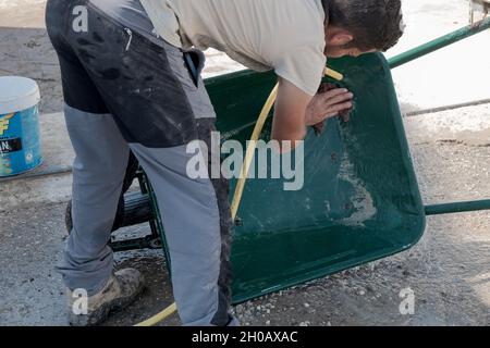 young worker cleaning forklift after a day's work. Stock Photo