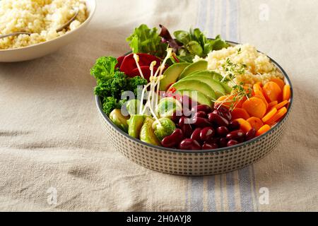 From above of delicious Buddha bowl dish made of various fresh vegetables and couscous served for healthy lunch on table Stock Photo