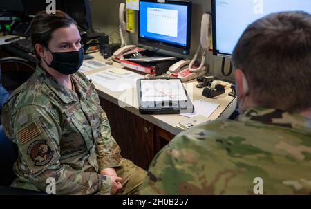 Senior Airman Kristina Grafton, 436th Operation Support Squadron airfield management operations supervisor, speaks with Senior Airman Keyton Nickell, 436th Airfield Operation Support Squadron airfield management shift lead, about current construction on the flight line at Dover Air Force Base, Delaware, Jan. 14, 2021. As airfield management journeymen, Grafton and Nickell manage airfield operations, which include coordinating with civil engineers, safety, air traffic control and various other base agencies to ensure safe aircraft operations within the airfield of Dover AFB. Stock Photo