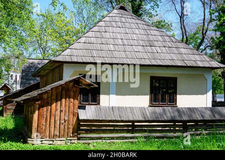 Bucharest, Romania - 25 April 2021: Old traditional Romanian house surounded with many old trees and green grass in Dimitrie Gusti National Village Mu Stock Photo