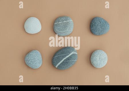 Set of sea stones of a round form on beige background. Top view of a collection of smooth pebbles. Stock Photo