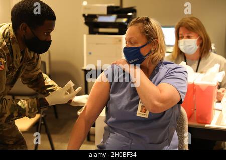 Spc. Anthony Shepherd, a medic assigned to the 224th Medical Company Area Support, Maryland Army National Guard, prepares to administer a COVID-19 vaccine Jan. 18, 2021, at Anne Arundel Community College in Arnold, Md. Maryland Guard members are supporting the COVID-19 vaccination initiative with mobile vaccination support teams, which are providing medical and logistical support to county health departments during the global COVID-19 pandemic. Stock Photo