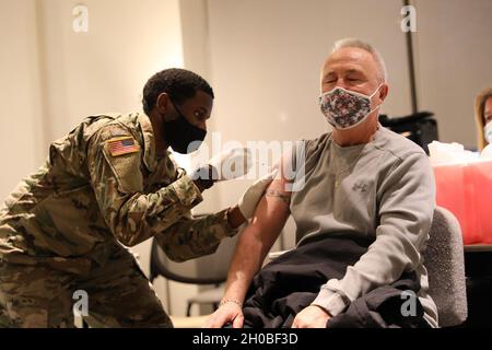 Spc. Anthony Shepherd, a medic assigned to the 224th Medical Company Area Support, Maryland Army National Guard, administers a COVID-19 vaccine Jan. 18, 2021, at Anne Arundel Community College in Arnold, Md. Maryland Guard members are supporting the COVID-19 vaccination initiative with mobile vaccination support teams, which are providing medical and logistical support to county health departments during the global COVID-19 pandemic. Stock Photo