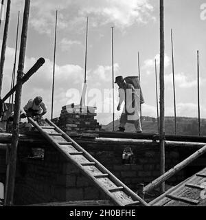 Baurbeiter auf einer Baustelle für den Neubau eines Hauses, Deutschland 1930er Jahre. Workers at a construction area to buidl a house, Germany 1930s. Stock Photo