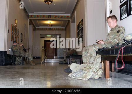 U.S. Army Spc. John Colford, right, of the California Army National Guard’s Bravo Company, 1st Battalion, 184th Infantry Regiment, 79th Infantry Brigade Combat Team, and other Cal Guardsmen rest inside the California Court of Appeal, Third Appellate District, in downtown Sacramento, California, Jan. 20, 2021. For almost a week Cal Guard forces have been providing 24-hour security at federal and state facilities throughout the state as the nation awaited newly-elected President Biden’s inauguration. Stock Photo