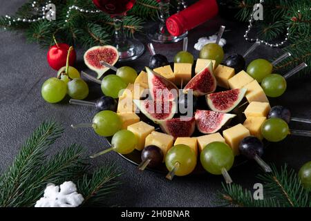 Canapes with cheese, grapes and figs. Holiday Party Snack for wine on dark gray background Stock Photo