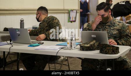 U.S. Navy Corpsmen with II MEF prepare to check-in Marines in-order to receive vaccine on Camp Lejeune, N.C., Jan. 20, 2021. Vaccination distribution prioritization within the DoD and the Marine Corps will be consistent with the data driven CDC guidance for national prioritization. Marines will continue to practice safety protocols to diminish the risk of COVID-19. Stock Photo