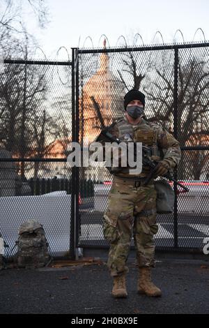 U.S. Army Sgt. Cody Anderson with Bravo Company, 1st Battalion, 128th Infantry, Wisconsin National Guard, stands guard in Washington, D.C., Jan. 20, 2021. At least 25,000 National Guard men and women have been authorized to conduct security, communication and logistical missions in support of federal and District authorities leading up and through the 59th Presidential Inauguration. Stock Photo