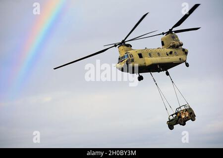 U.S. Army paratroopers assigned to Attack Company, 1st Battalion, 503rd Infantry Regiment, 173rd Airborne Brigade, conduct sling load operations with a CH-47 Chinook helicopter, from 6-101 GSAB, 101 CAB, Illesheim, Germany, during exercise Eagle Talon, Monte Romano, Italy, Jan 20, 2021. Stock Photo