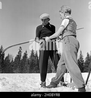 Zwei Skifahrer fachsimpeln über ihre Skier, Deutschland 1930er Jahre. Two ski tourists talking shop about their skis, Germany 1930s. Stock Photo