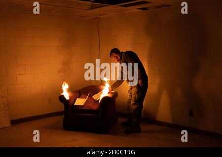 U.S. Air Force Maj. Branden DeLong, 51st Civil Engineer Squadron operations flight commander, lights a piece of old furniture on fire at Osan Air Base, South Korea, Jan. 21, 2021.  The controlled fire, which took place in a divested dorm building scheduled for demolition, allowed simulated real-world training for the Osan Fire Department. Stock Photo