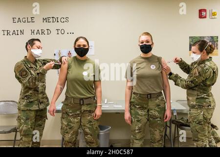 Senior Airman Bianca Robichaud, 436th Health Care Operations Squadron acting family health noncommissioned officer in charge, and Staff Sgt. Kelsey Loeser, 436th Medical Group unit training manager, administer the COVID-19 vaccine to Lt. Col. Kristen Carter, 436th Medical Support Squadron commander, and Master Sgt. Jessica Nienhueser, 436th MDSS superintendent, Jan. 21, 2021, at Dover Air Force Base, Delaware. Carter and Nienhueser were among the first Team Dover front-line workers who voluntarily received the vaccine in accordance with Department of Defense guidance. The vaccine was granted e Stock Photo