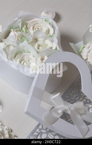 Homemade marshmallow in a gift box. Zephyr roses.  Heart shaped box. Tied with a ribbon tied to a bow. Marshmallow roses.  Heart shaped box. Stock Photo