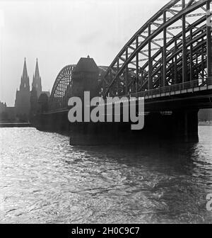 Blick von der rechten Rheinseite in Deutz auf die Hohenzollernbrücke und den Hohen Dom zu Köln, 1930er Jahre. View from the eastern shore of the river Rhine to the Hohenzollerbruecke railway bridge and the famous cathedral of Cologne, 1930s. Stock Photo