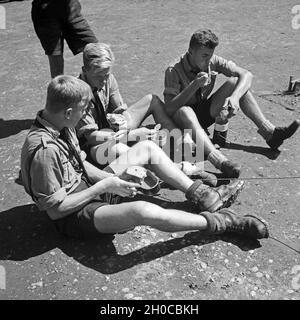 Drei Hitlerjungen sitzen in der Mittagspause zusammen beim feldmäßigen Essen, Österreich 1930er Jahre. Three Hitler youths sitting together and having lunch break, Austria 1930s. Stock Photo