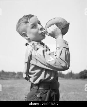 Ein Hitlerjunge nimmt einen Schluck aus seiner Feldflasche, Deutschland 1930er Jahre. A Hitler youth drinking from his waterbottle, Germany 1930s. Stock Photo