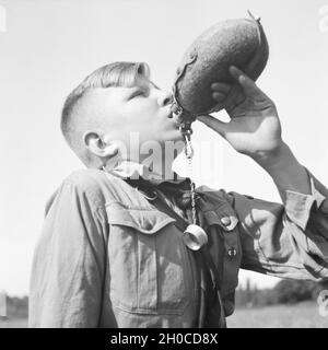 Ein Hitlerjunge nimmt einen Schluck aus seiner Feldflasche, Deutschland 1930er Jahre. A Hitler youth drinking from his waterbottle, Germany 1930s. Stock Photo