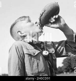 Ein Hitlerjunge nimmt einen Schluck aus seiner Feldflasche, Deutschland 1930er Jahre. A Hitler youth drinking from his waterbottle, Germany 1930s. Stock Photo