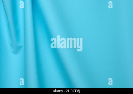 Textured background made of soft blue fabric with elegant pleats. Selective focus. Stock Photo