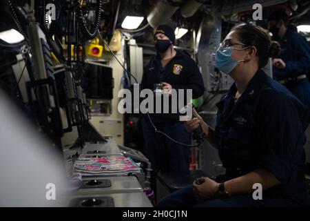 PACIFIC OCEAN (Jan. 22, 2021) Fire Control Technician 2nd Class Rebecca Jessen, from Dayton, Ohio, assigned to the Gold crew of the Ohio-class guided-missile submarine USS Ohio (SSGN 726), searches for surface contacts through the scope while standing watch in control. Ohio is conducting surveillance, training, and other critical missions in the U.S. 7th Fleet area of operation. Stock Photo