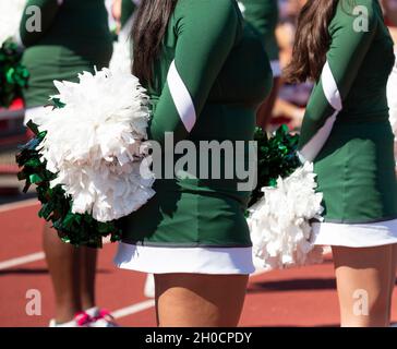 Cheerleaders in White Uniform Holding Pom-Poms. Close Up Stock