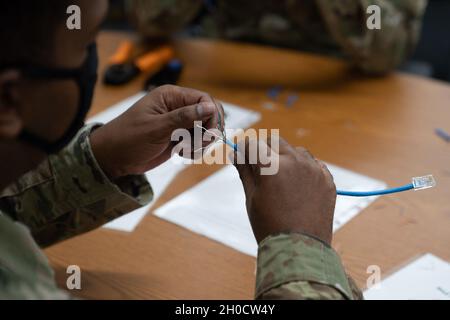 U.S. Air Force Tech. Sgt. Jermaine Miles, 338th Training Squadron instructor, demonstrates how to make an ethernet cable in Bryan Hall at Keesler Air Force Base, Mississippi, on Jan. 26, 2021. The 338th TRS has been working towards a modular curriculum, which enables students to receive the training tailored to their future assignment, for approximately five years. Stock Photo