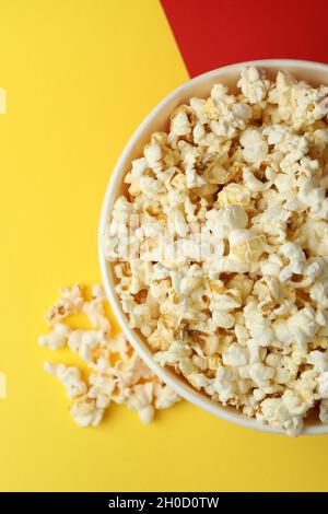 Striped paper cup with popcorn on two tone background. Stock Photo