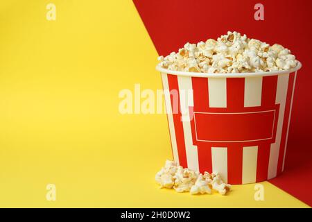 Striped paper cup with popcorn on two tone background. Stock Photo