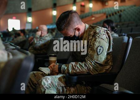 Staff Sgt. Eldon Woodie, assigned to Comanche Troop, 2nd Squadron, 14th Cavalry Regiment, 2nd Infantry Brigade Combat Team, 25th Infantry Division, studiously writes notes as a facilitator speaks on common leadership qualities during the Division Squad Leader Forum at Sgt. Smith Theater on Schofield Barracks, Hawaii, Jan. 27, 2021. Junior non-commissioned officers own the culture of small units and are empowered to care for their Soldiers and families. Stock Photo