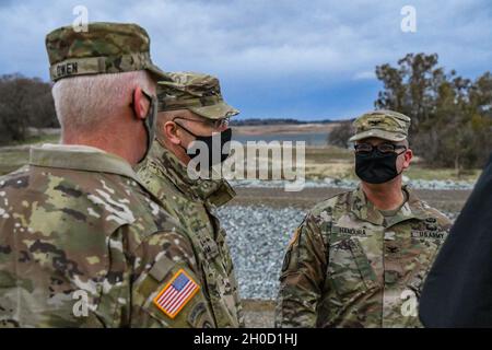 Maj. Gen. William Graham, center, deputy commanding general for civil and emergency operations for the U.S. Army Corps of Engineers, speaks with Brig. Gen. Paul Owen, right, commanding general of the South Pacific Division, and Col. James Handura, commander of the Sacramento District at Folsom Dam Dike 8 Jan. 27, 2021. Maj. Gen. Graham came to visit several district projects including Dike 8, Lower Cache Creek and the Sacramento Weir as part of a larger visit to the South Pacific Division. At each site, the general heard from project leaders within USACE and any other interagency collaborators Stock Photo