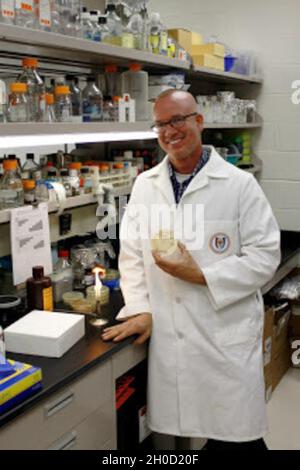 Dr. Michael Daly, professor of Pathology at the Uniformed Services University (USU), holds a petri dish containing Deinococcus radiodurans, a bacterium famous for its extreme resistance to radiation that may hold the key to faster vaccine development. Stock Photo
