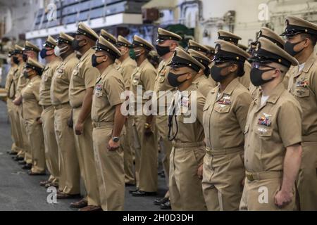 PHILIPPINE SEA (Jan. 29, 2021) Newly promoted chief petty officers assigned to USS America (LHA 6), the Navy’s only forward-deployed amphibious assault ship, stand in formation during a ceremony in the ship’s hangar bay. The Navy is unique among the services in recognizing and celebrating promotion to E-7 as a major milestone in a Sailor’s career. America, flagship of the America Expeditionary Strike Group, along with the 31st Marine Expeditionary Unit, is operating in the U.S. 7th Fleet area of responsibility to enhance interoperability with allies and partners and serve as a ready response f Stock Photo