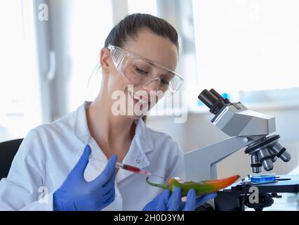 Young woman scientist doing research on pepper in laboratory Stock Photo