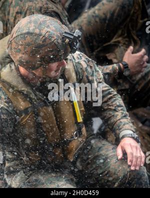 A U.S. Marine with Battalion Landing Team, 3rd Battalion, 4th Marines, 31st Marine Expeditionary Unit (MEU), prepares to debark from a combat rubber raiding craft while returning from a boat raid rehearsal aboard dock landing ship USS Ashland (LSD 48) in the Philippine Sea on Jan. 28, 2021. The 31st MEU is operating aboard ships of the America Expeditionary Strike Group in the 7th fleet area of operations to enhance interoperability with allies and partners and serve as a ready response force to defend peace and stability in the Indo-Pacific Region. Stock Photo