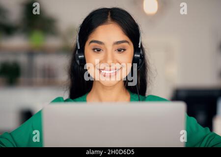 Closeup of beautiful indian woman attending online course, using laptop Stock Photo