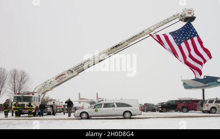 Members of the Geneseso, NY Fire Department and the New York State Police salute a passing hearse carrying the remains of Chief Warrant Officer 4 Christian Koch, Jan. 29. Koch, a UH-60 Blackhawk pilot assigned to Charlie Company, 1-171 General Support Aviation Battalion, died when his helicopter crashed during a training flight Jan. 20 outside Rochester, NY Stock Photo